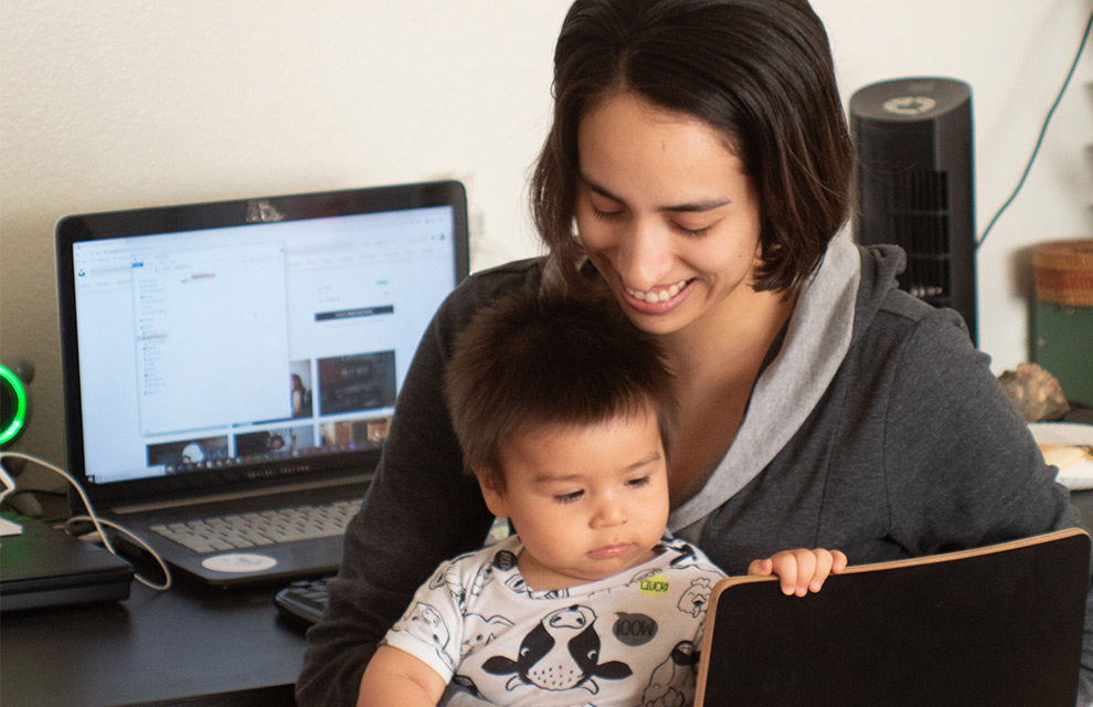 working mother holding baby symbolizing balancing maternity and career